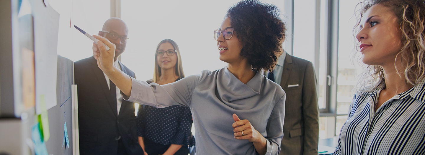 woman with sharpie pointing to board